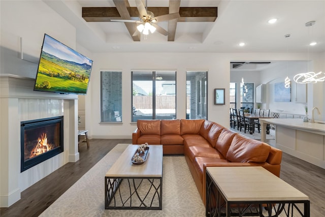 living room featuring beamed ceiling, ceiling fan, coffered ceiling, and dark hardwood / wood-style flooring