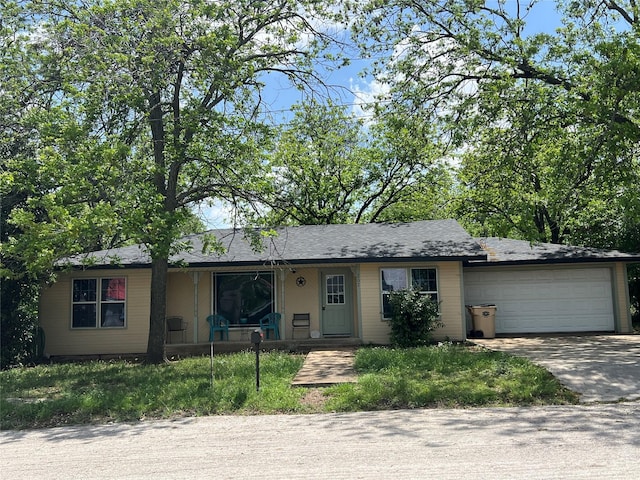 single story home featuring a front yard, a porch, and a garage