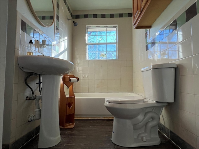 bathroom featuring tiled shower / bath combo, hardwood / wood-style floors, and toilet