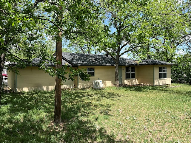 rear view of property with a yard and ac unit