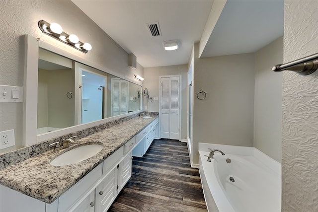 bathroom featuring vanity, wood-type flooring, and a bathing tub