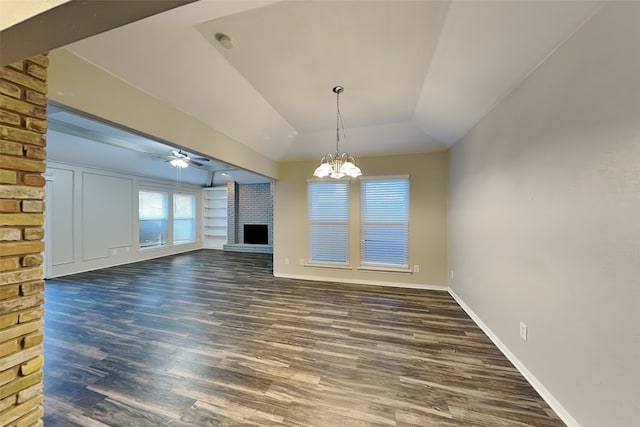 unfurnished living room featuring vaulted ceiling, ceiling fan with notable chandelier, dark wood-type flooring, and a fireplace