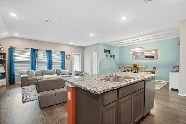 kitchen featuring dark wood-type flooring, sink, stainless steel dishwasher, and a center island with sink