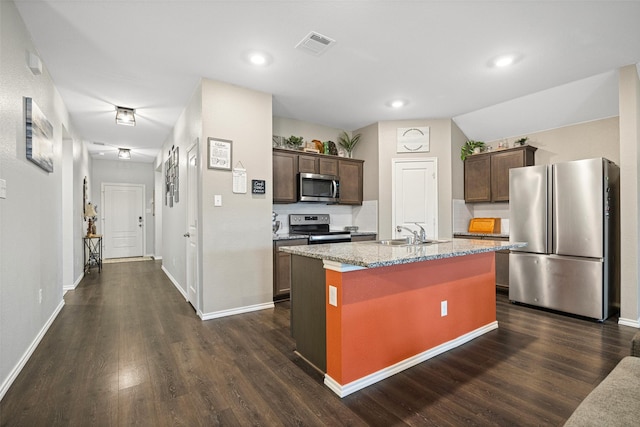 kitchen with dark brown cabinets, stainless steel appliances, a center island with sink, and sink