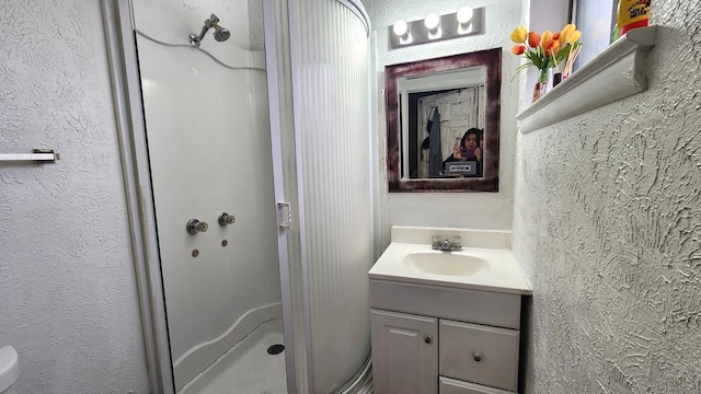 bathroom featuring walk in shower and vanity