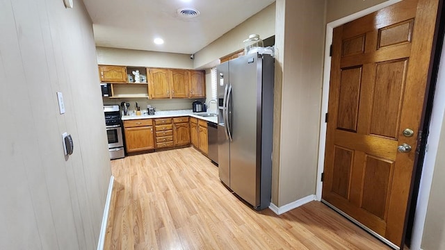 kitchen with sink, light hardwood / wood-style flooring, and appliances with stainless steel finishes