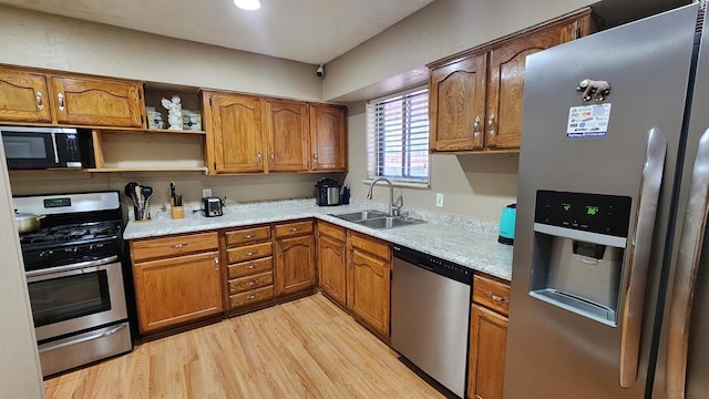 kitchen with sink, stainless steel appliances, and light hardwood / wood-style floors