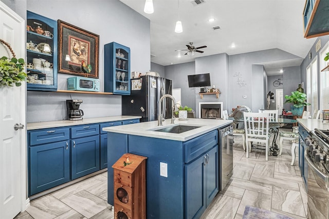 kitchen with sink, blue cabinetry, an island with sink, and stainless steel appliances