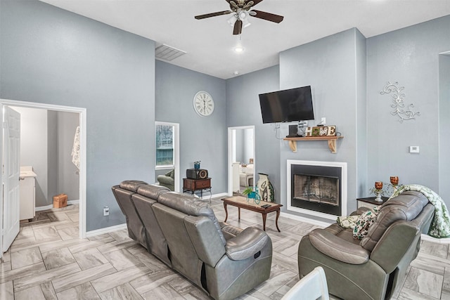 living room featuring a high ceiling, light parquet floors, and ceiling fan