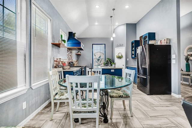 dining space featuring vaulted ceiling, sink, and light parquet floors