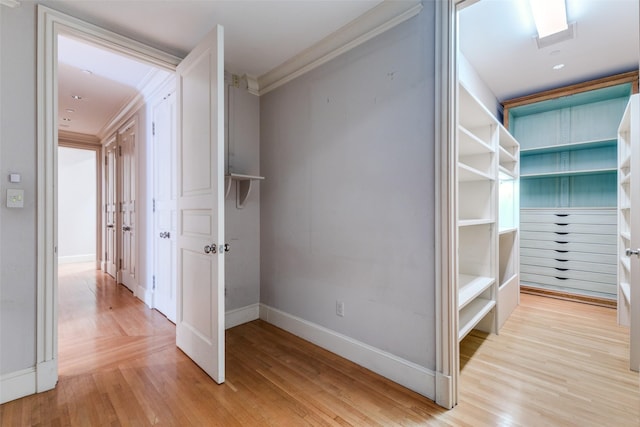 corridor featuring crown molding and light wood-type flooring