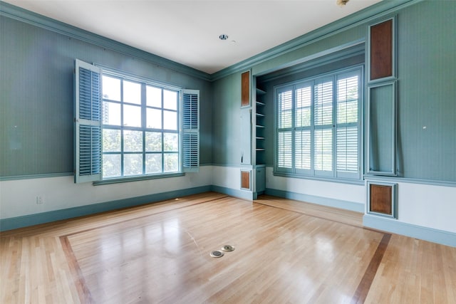 unfurnished room with crown molding and wood-type flooring