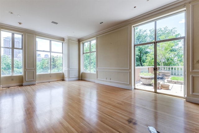 unfurnished room with light wood-type flooring and ornamental molding