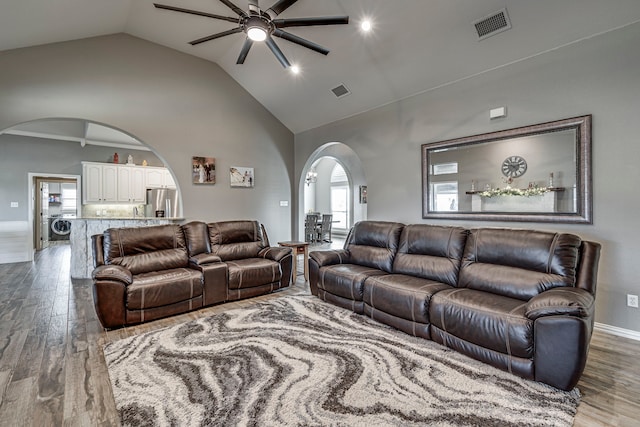 living room with ceiling fan, washer / dryer, light hardwood / wood-style flooring, and lofted ceiling