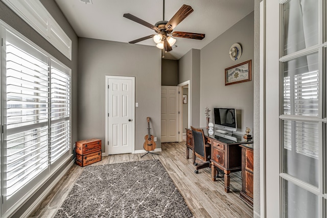 home office with light hardwood / wood-style floors, a healthy amount of sunlight, and ceiling fan