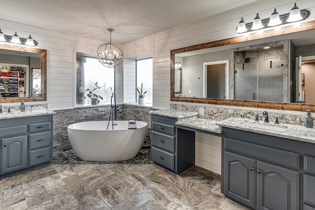 bathroom with a notable chandelier, vanity, separate shower and tub, and wooden walls