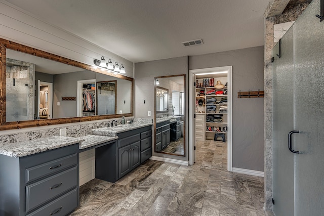 bathroom featuring a shower with shower door, a textured ceiling, and vanity