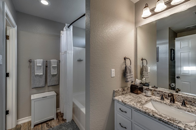 bathroom featuring hardwood / wood-style floors, shower / bath combination with curtain, and vanity