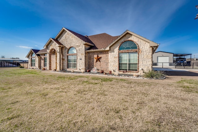 view of front of property with a front yard, an outbuilding, and a garage