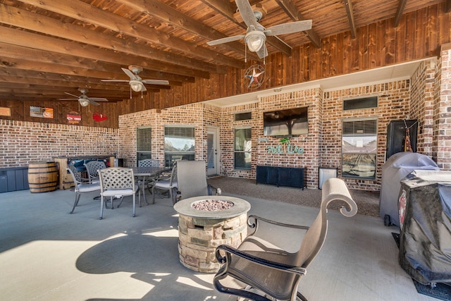 view of patio featuring ceiling fan, area for grilling, and a fire pit