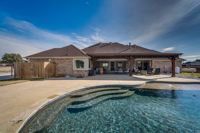 back of house with a fenced in pool and a patio