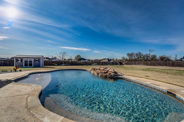 view of pool featuring an outbuilding and a lawn