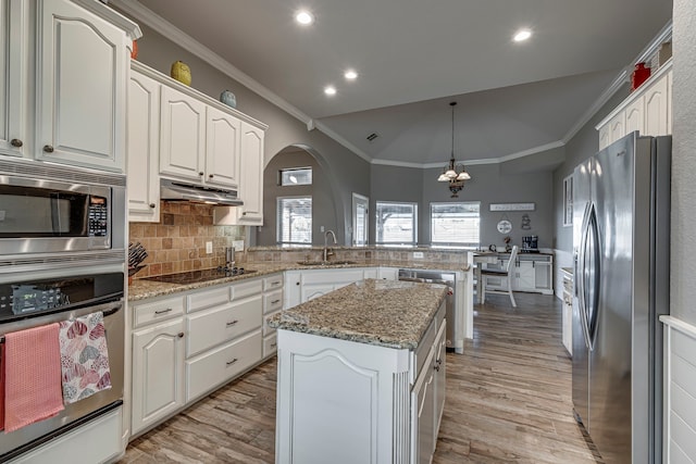 kitchen with a center island, hanging light fixtures, white cabinets, kitchen peninsula, and stainless steel appliances