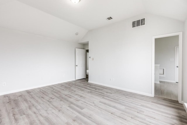 spare room with lofted ceiling and light hardwood / wood-style floors