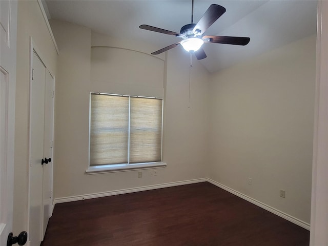 empty room featuring dark wood-type flooring, vaulted ceiling, and ceiling fan