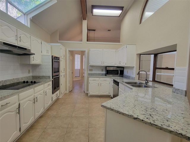 kitchen featuring white cabinetry, stainless steel appliances, light stone countertops, and light tile patterned floors