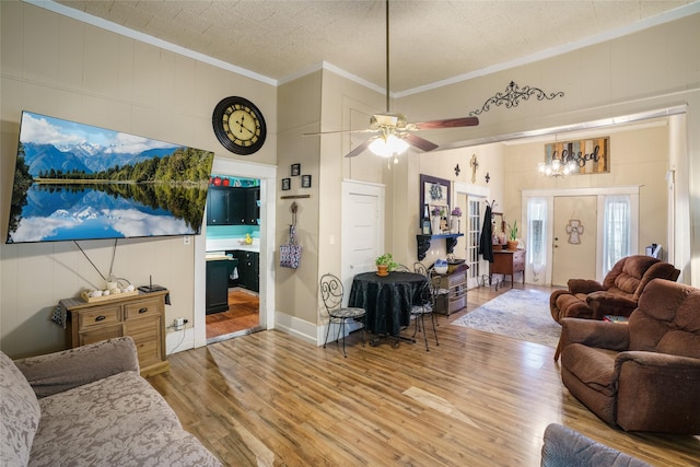 living room featuring ceiling fan, ornamental molding, and wood-type flooring