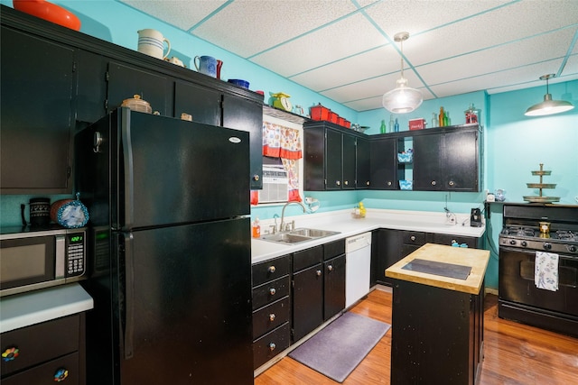 kitchen featuring black appliances, a center island, a paneled ceiling, and hanging light fixtures