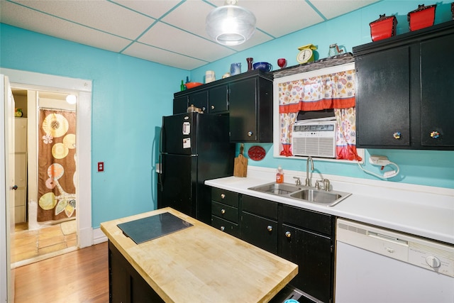 kitchen featuring hardwood / wood-style floors, white dishwasher, sink, black fridge, and a paneled ceiling