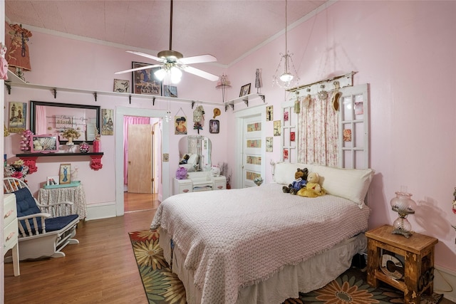 bedroom with crown molding, hardwood / wood-style floors, and ceiling fan