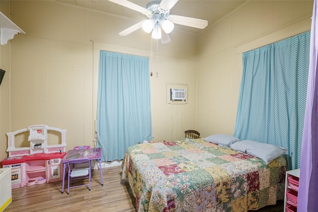 bedroom featuring ceiling fan, an AC wall unit, light hardwood / wood-style flooring, and crown molding