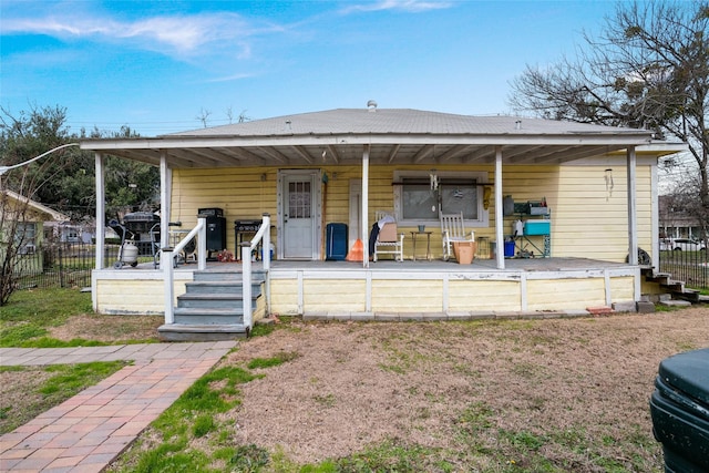 back of property featuring covered porch