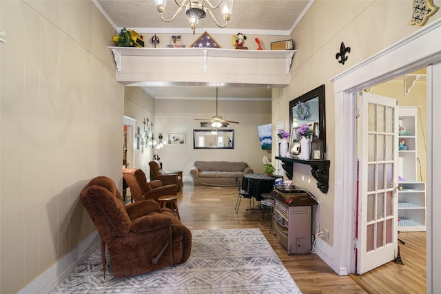 interior space featuring crown molding, hardwood / wood-style flooring, and ceiling fan with notable chandelier