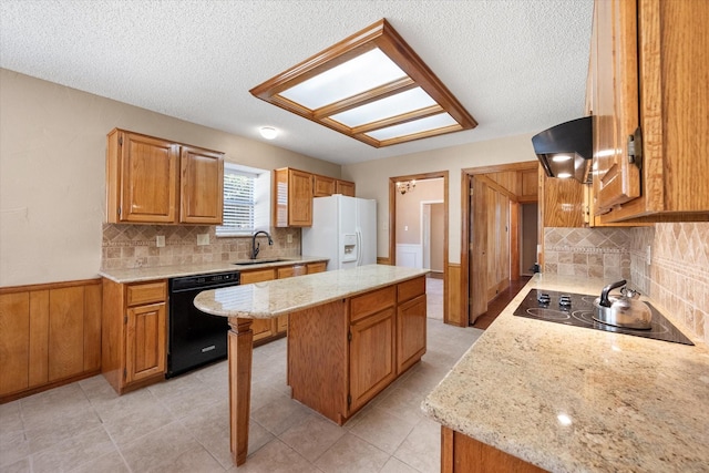 kitchen featuring a kitchen breakfast bar, sink, tasteful backsplash, a kitchen island, and black appliances