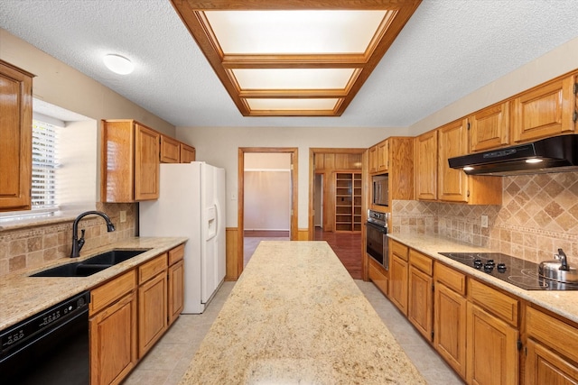 kitchen with decorative backsplash, sink, black appliances, and light stone countertops