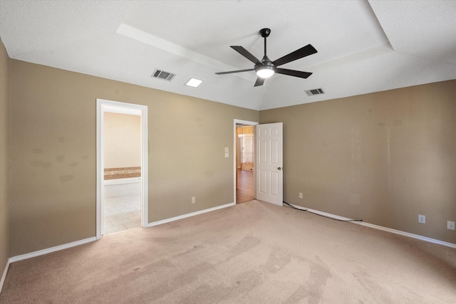 unfurnished bedroom with light colored carpet, ensuite bathroom, and ceiling fan