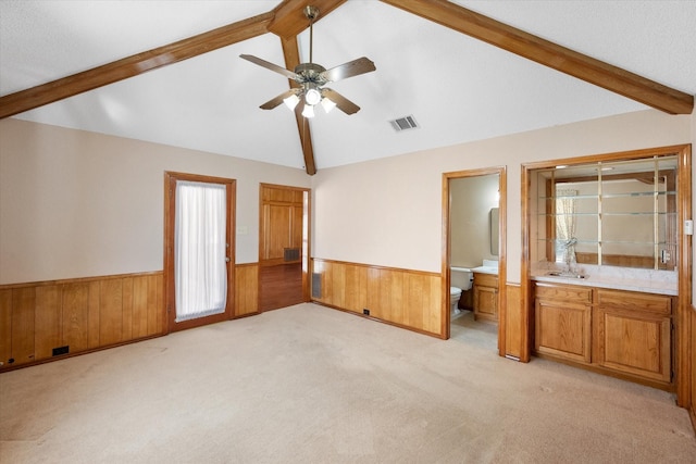 interior space featuring ceiling fan, vaulted ceiling, a healthy amount of sunlight, and light carpet