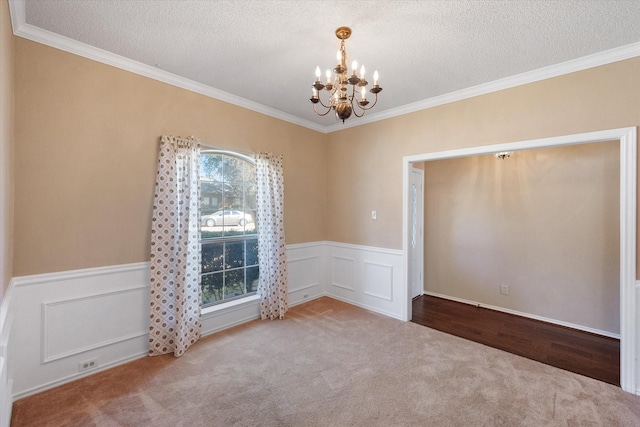 carpeted empty room featuring crown molding and a textured ceiling