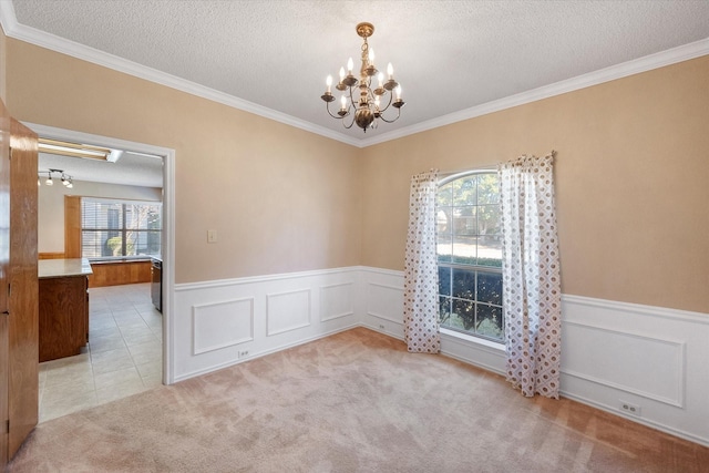 carpeted empty room featuring a chandelier, crown molding, and a textured ceiling