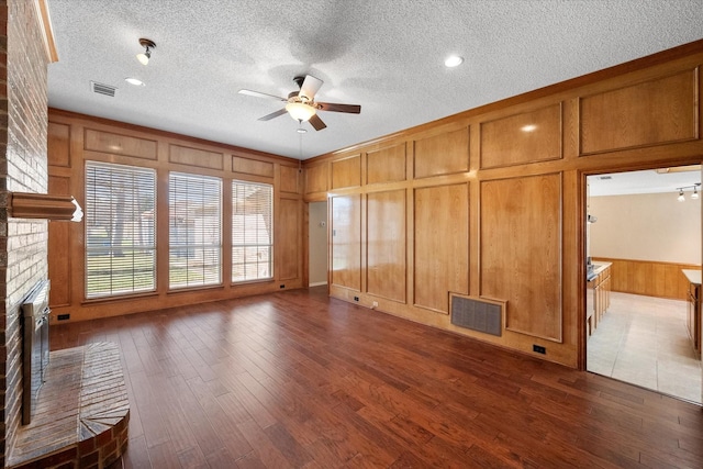 unfurnished living room with ceiling fan, dark hardwood / wood-style flooring, and a fireplace