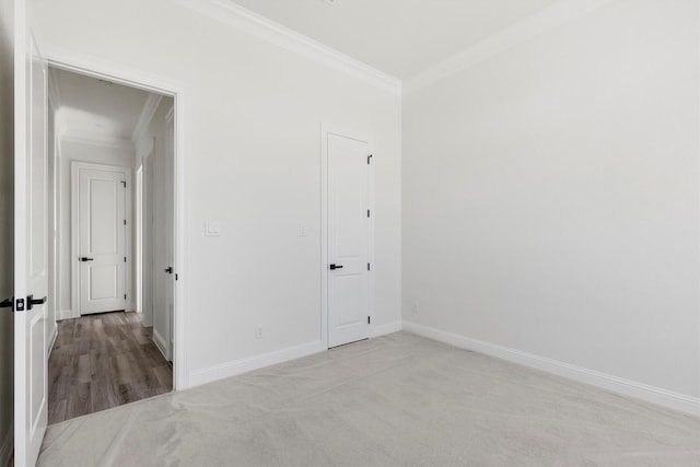 unfurnished bedroom featuring crown molding and light colored carpet