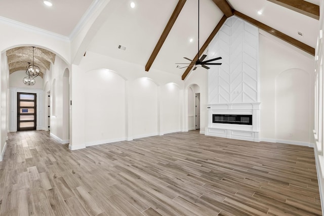 unfurnished living room featuring high vaulted ceiling, ceiling fan with notable chandelier, light hardwood / wood-style flooring, and a fireplace