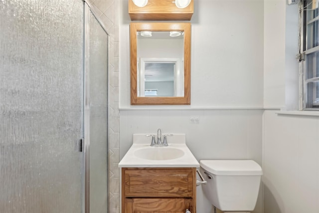 bathroom with vanity, a shower with shower door, and toilet