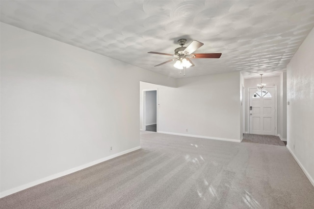 unfurnished room with ceiling fan with notable chandelier and light carpet