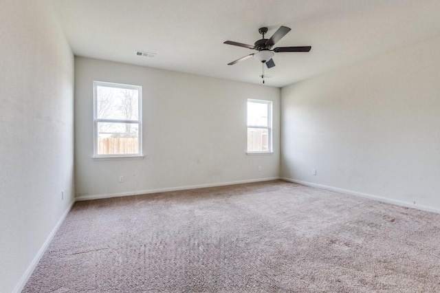 carpeted empty room featuring ceiling fan and plenty of natural light