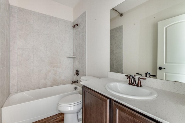 full bathroom with vanity, toilet, tiled shower / bath, and hardwood / wood-style floors